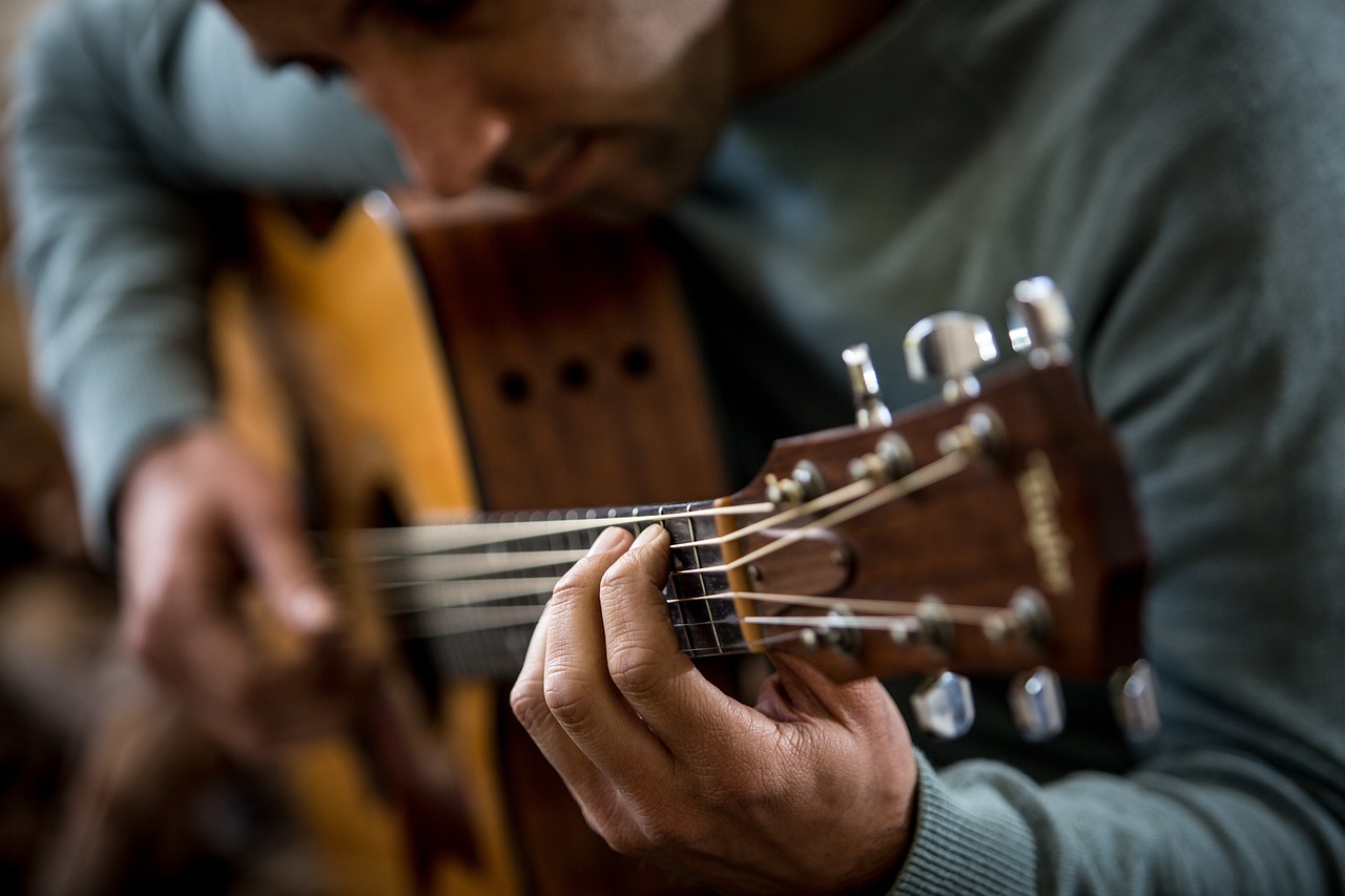An image showcasing a guitarist delicately stretching a fresh set of guitar strings